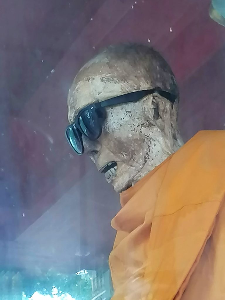 Le moine porte des lunettes de soleil en raison de la décomposition avancée de ses yeux et ce n'est pas très beau à voir.