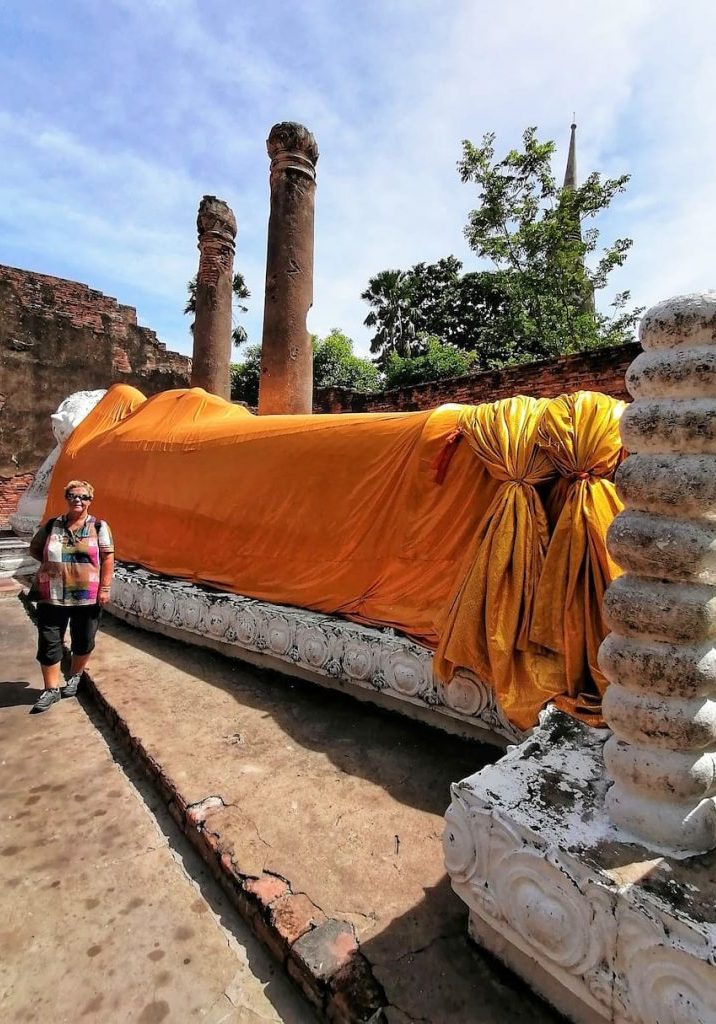 Les fidèles apposent des petites feuilles d'or sur les pieds de l'immense Bouddha couché, pour le porter bonheur et succès