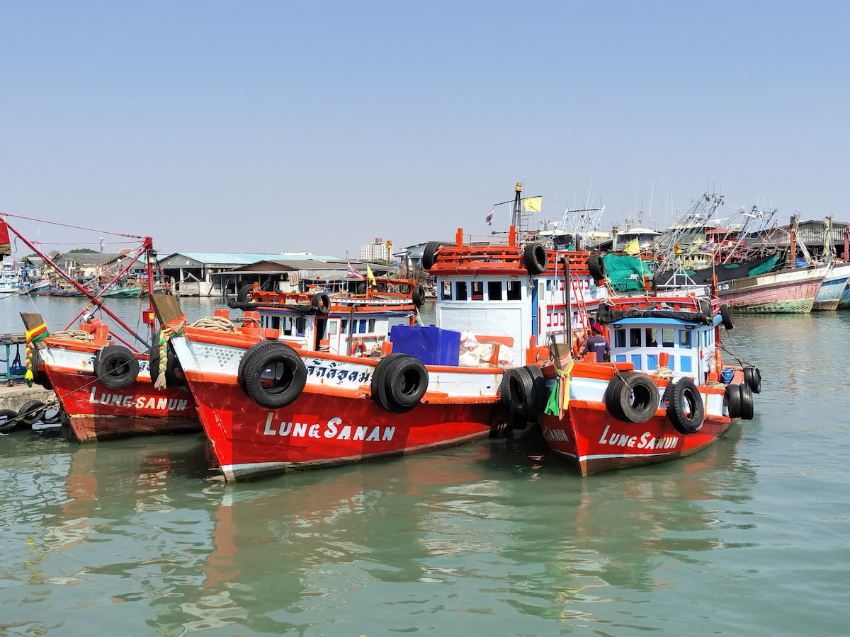 Le port de Rayong est très animé avec de nombreux bateaux traditionnels en bois.